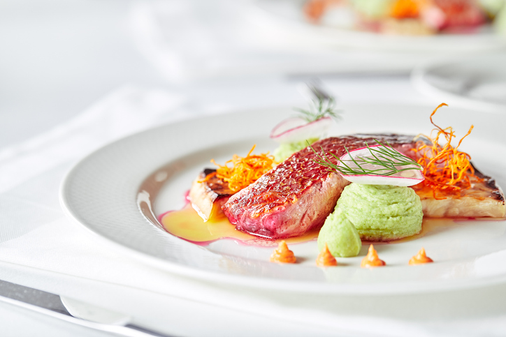 Tender dorado fillet with vegetables and basil. Banquet festive dishes. Gourmet restaurant menu. White background